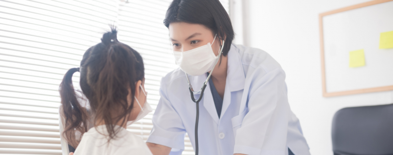 Pediatrician taking heart rate of young patient