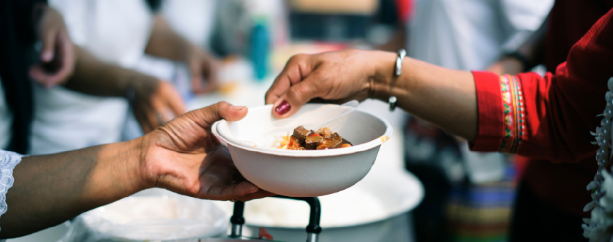 Hands passing a bowl of food