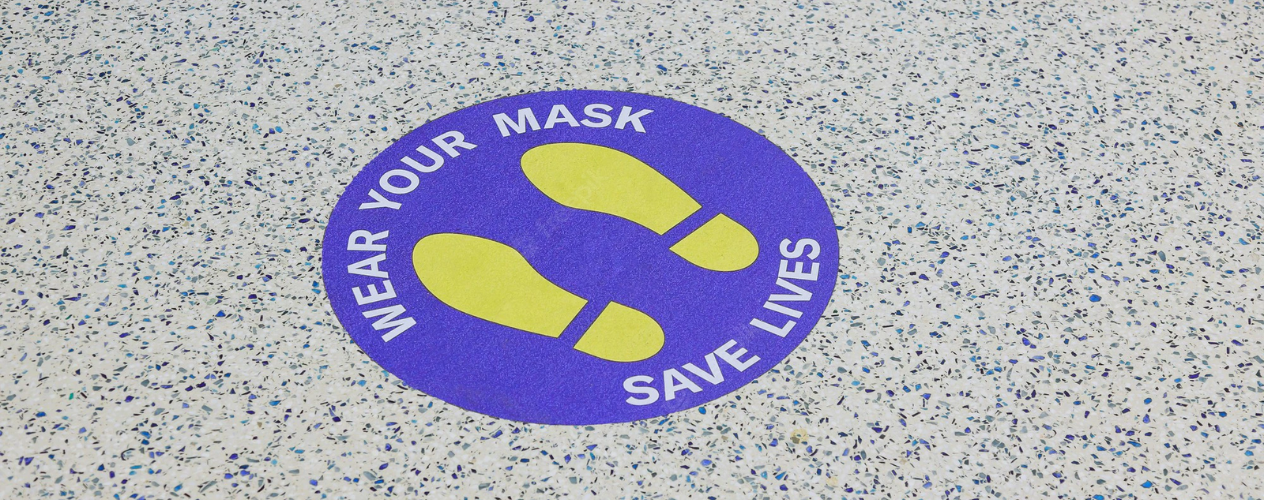 Sticker on floor saying: "Wear your mask, Save lives"