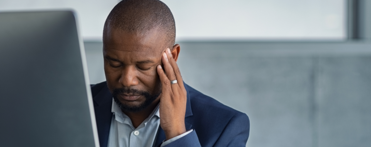 Stressed man looking at computer screen