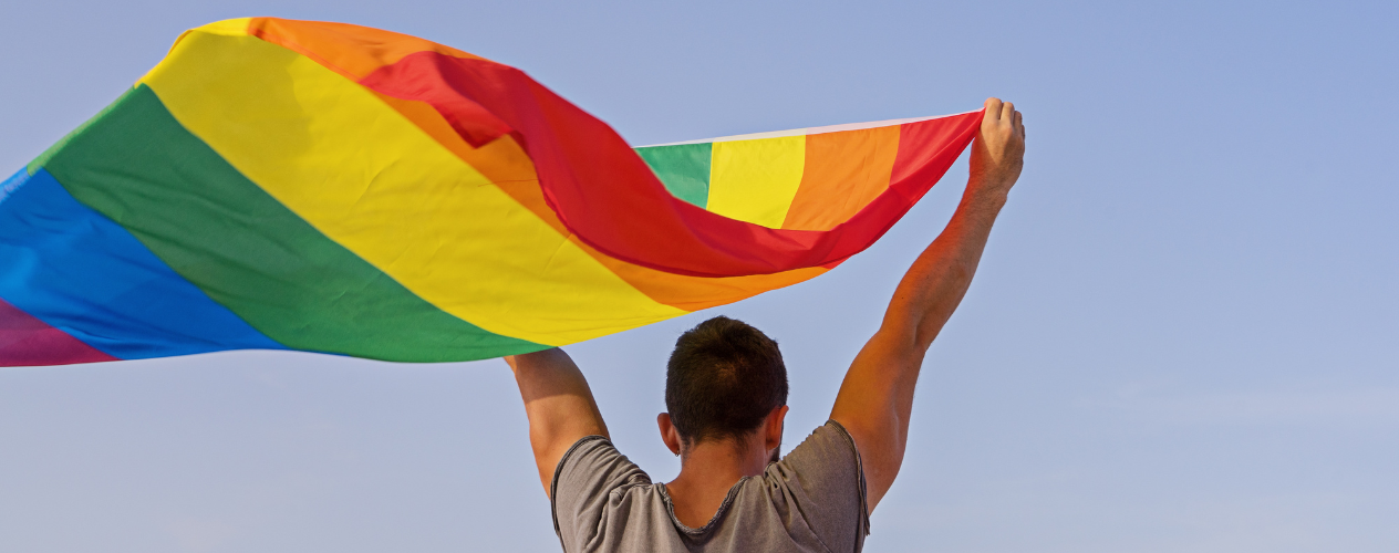 Individual holding LGBTQ flag