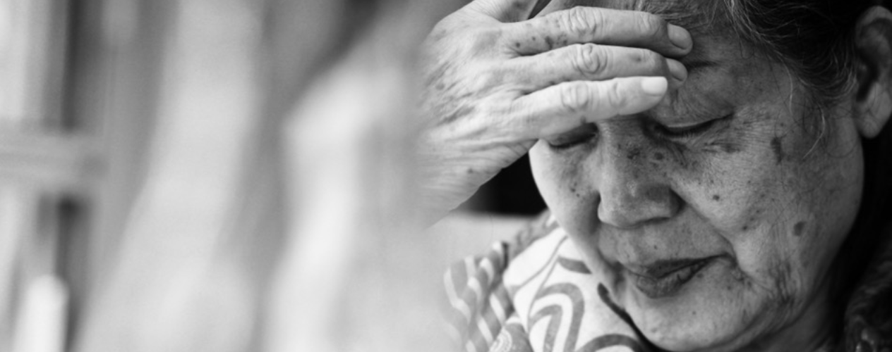 Elderly Asian-American women with hand to head, in distress