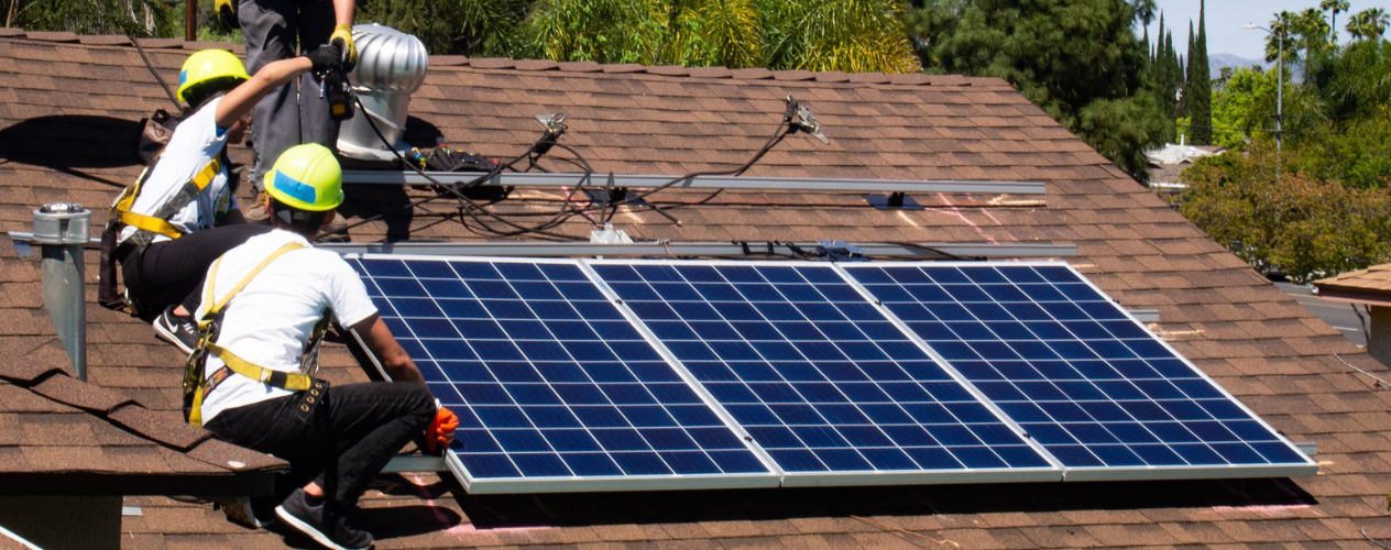 Trainees from GRID Alternatives install solar panels on a roof  in Los Angeles.