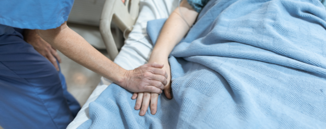 Close-up of doctor holding hand of patient
