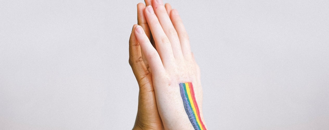 Two hands with a rainbow painted on them