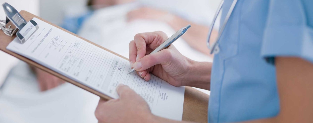 Doctor writing on clipboard