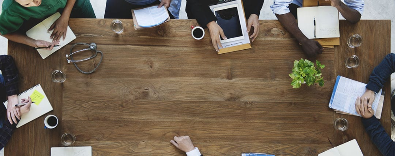 People surrounding a wood table