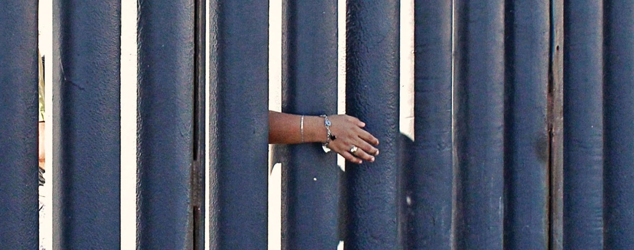 Hand reaching through a gate