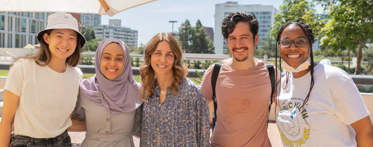 students and faculty smiling standing together outside