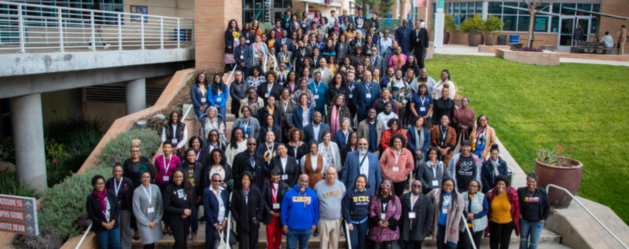 conference attendees standing on steps on campus