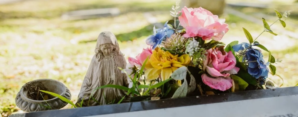 statue and flowers on a grave