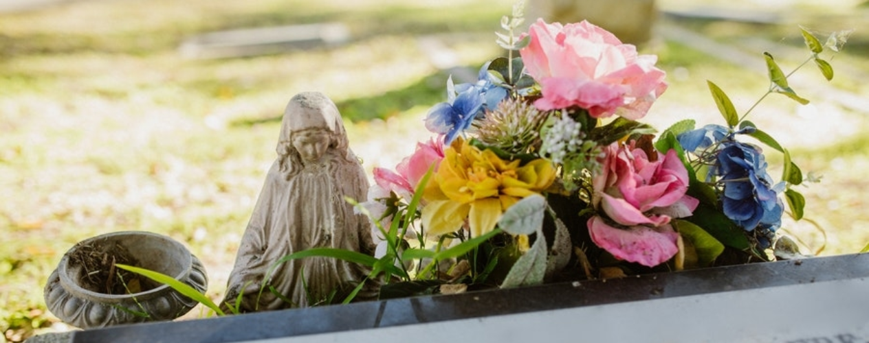 statue and flowers on a grave