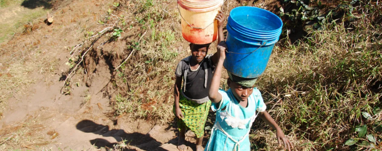 two children with buckets of water balanced on head