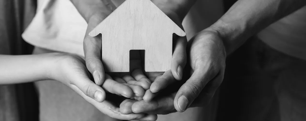 People holding wooden house