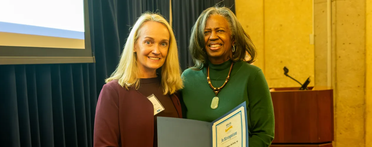 Dr. Julie Elginer, left, receives the award from Dr. Yolanda Gorman, Interim Associate Vice Chancellor, Alumni Affairs and CFO and COO of the UCLA Foundation.