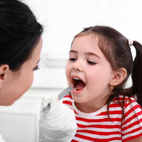 Pediatrician checking the mouth of a young child