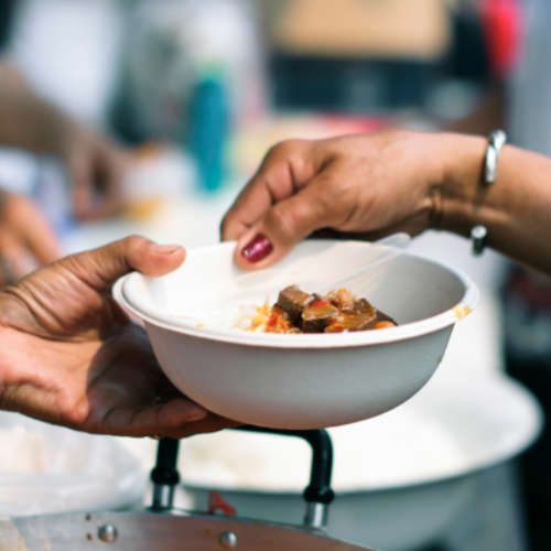 Hands passing a plate of food