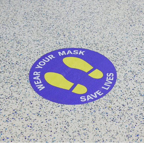 Sticker on floor saying: "Wear your mask, Save lives"