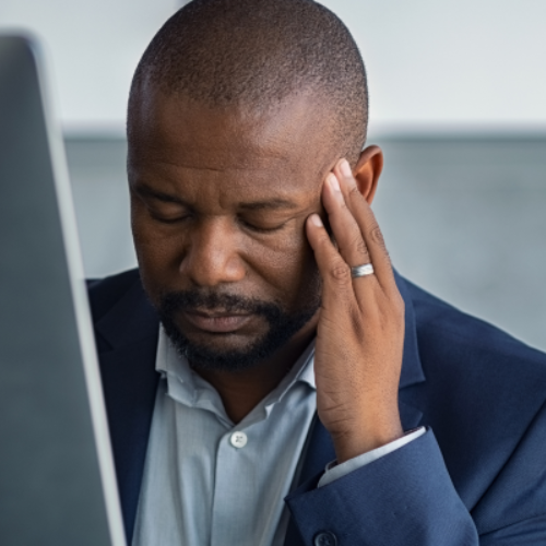 Stressed man looking at computer screen