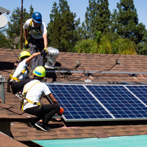 Trainees from GRID Alternatives install solar panels on a roof  in Los Angeles.