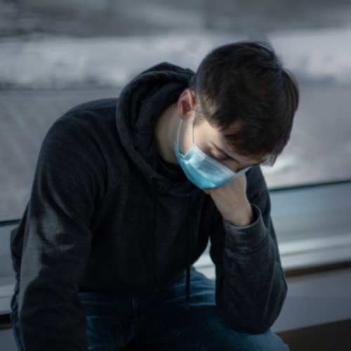 Teenager in black hood looking down