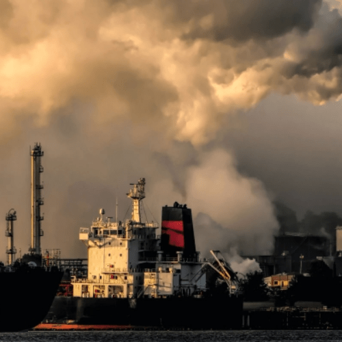 smoke/pollution billowing into the air over a factory