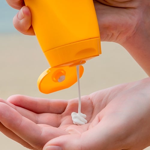 Sunscreen being squirted into someone's hand