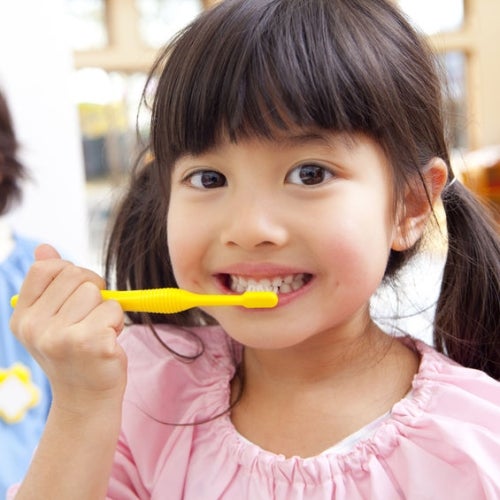 Kid brushing her teeth