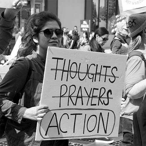 person holding sign with the word action circled