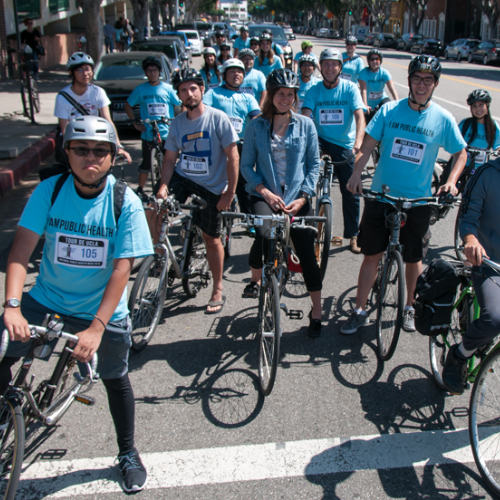 Photo of dozens of Tour de UCLA bike riders at a light in Westwood Village