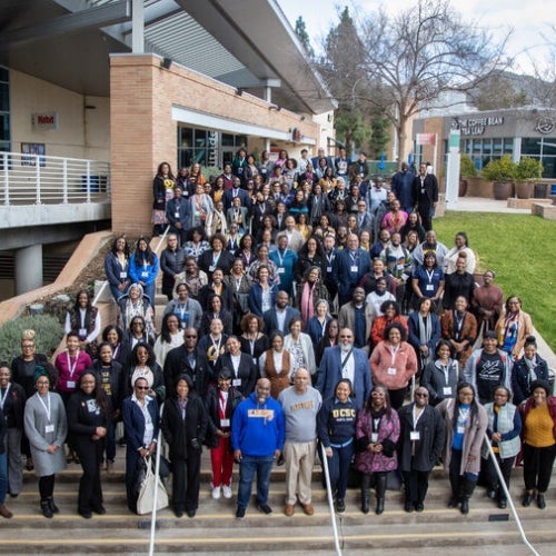 conference attendees standing on steps on campus
