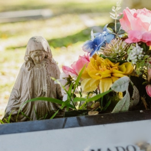 statue and flowers on a grave