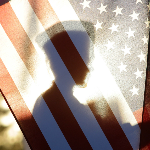 outline of veteran behind the US flag