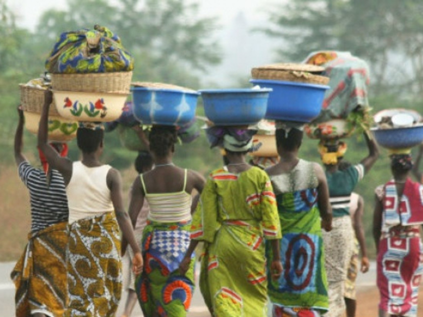 Women carrying baskets with produce on their heads.