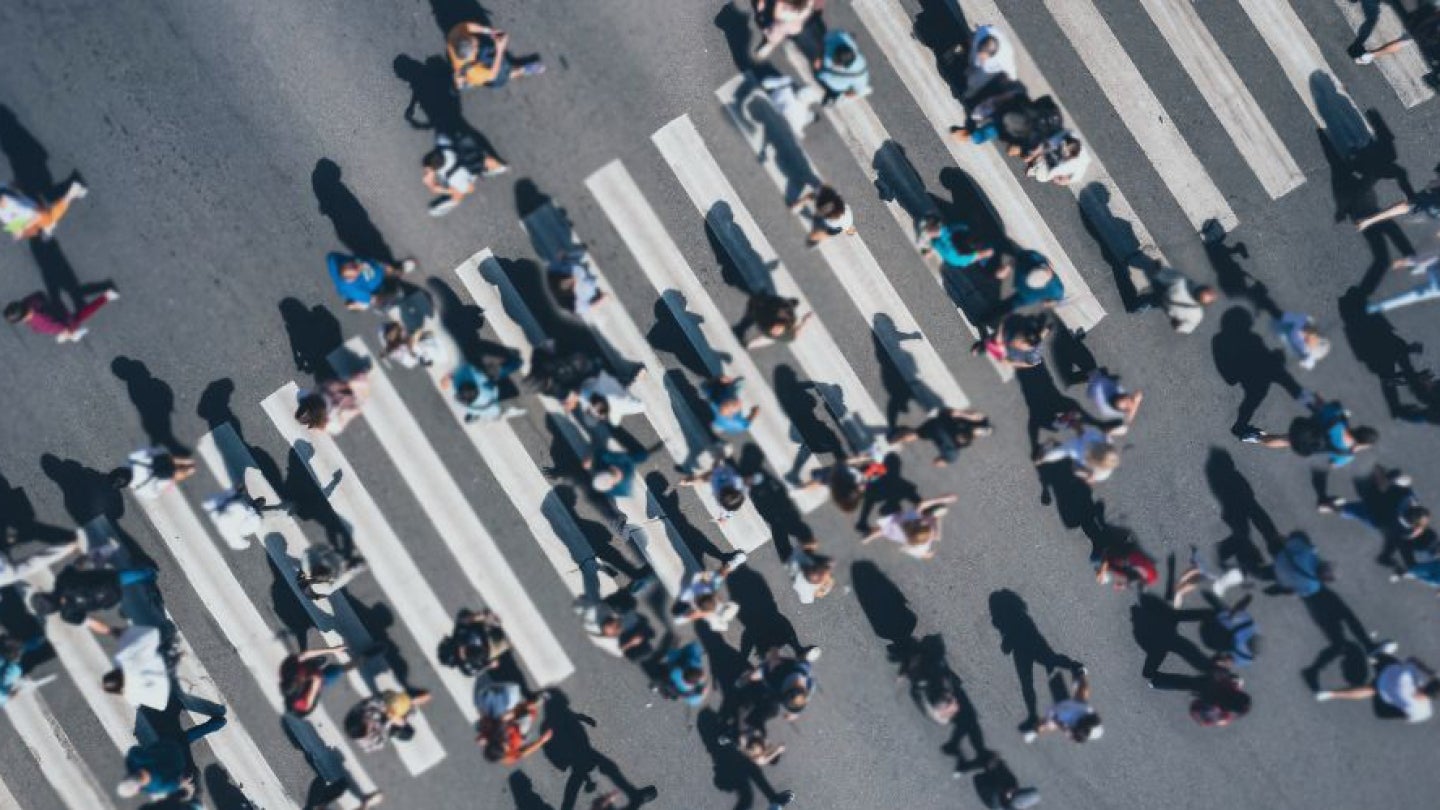 People walking through a busy crosswalk