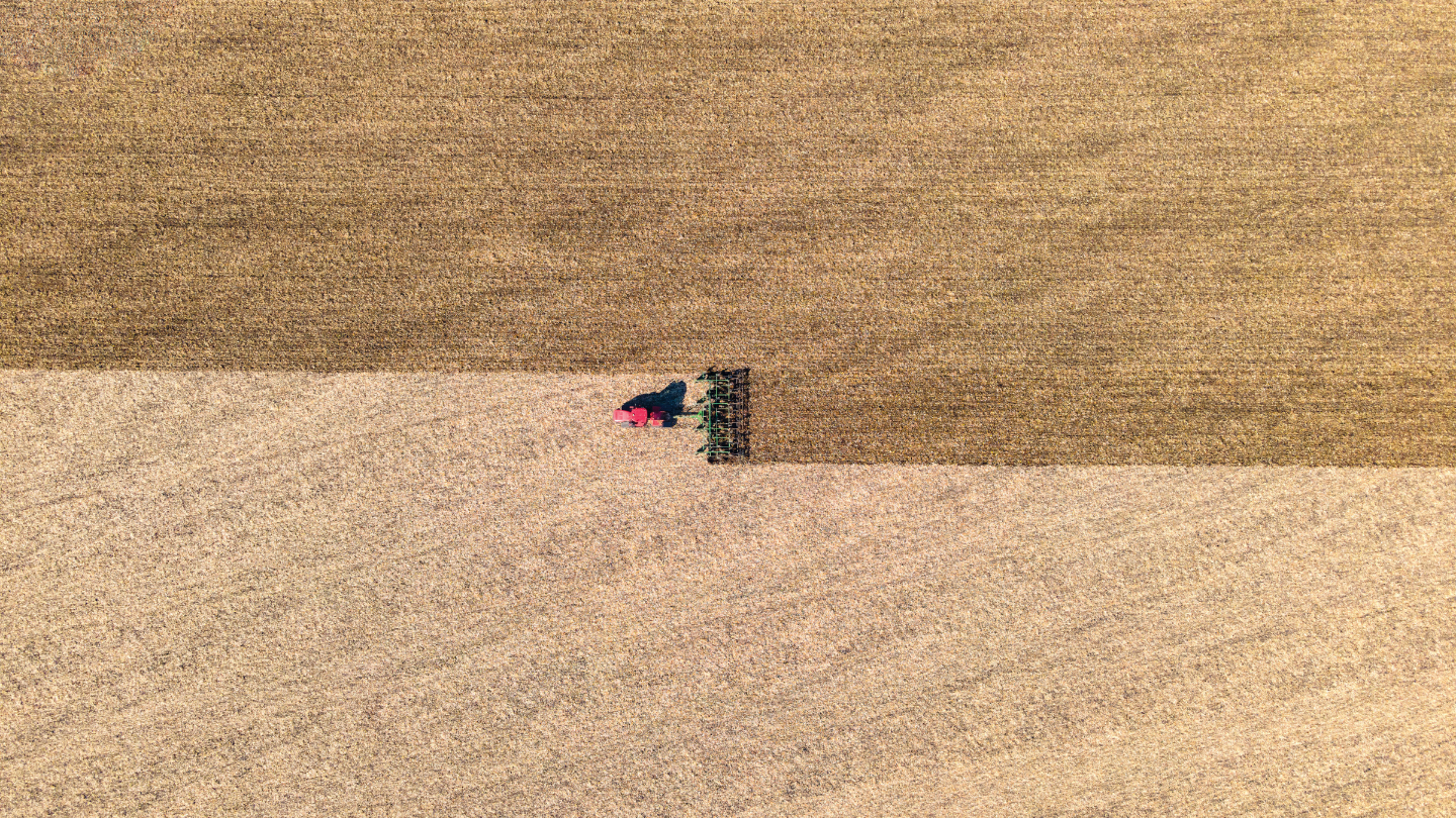 Overhead view of tractor plowing field