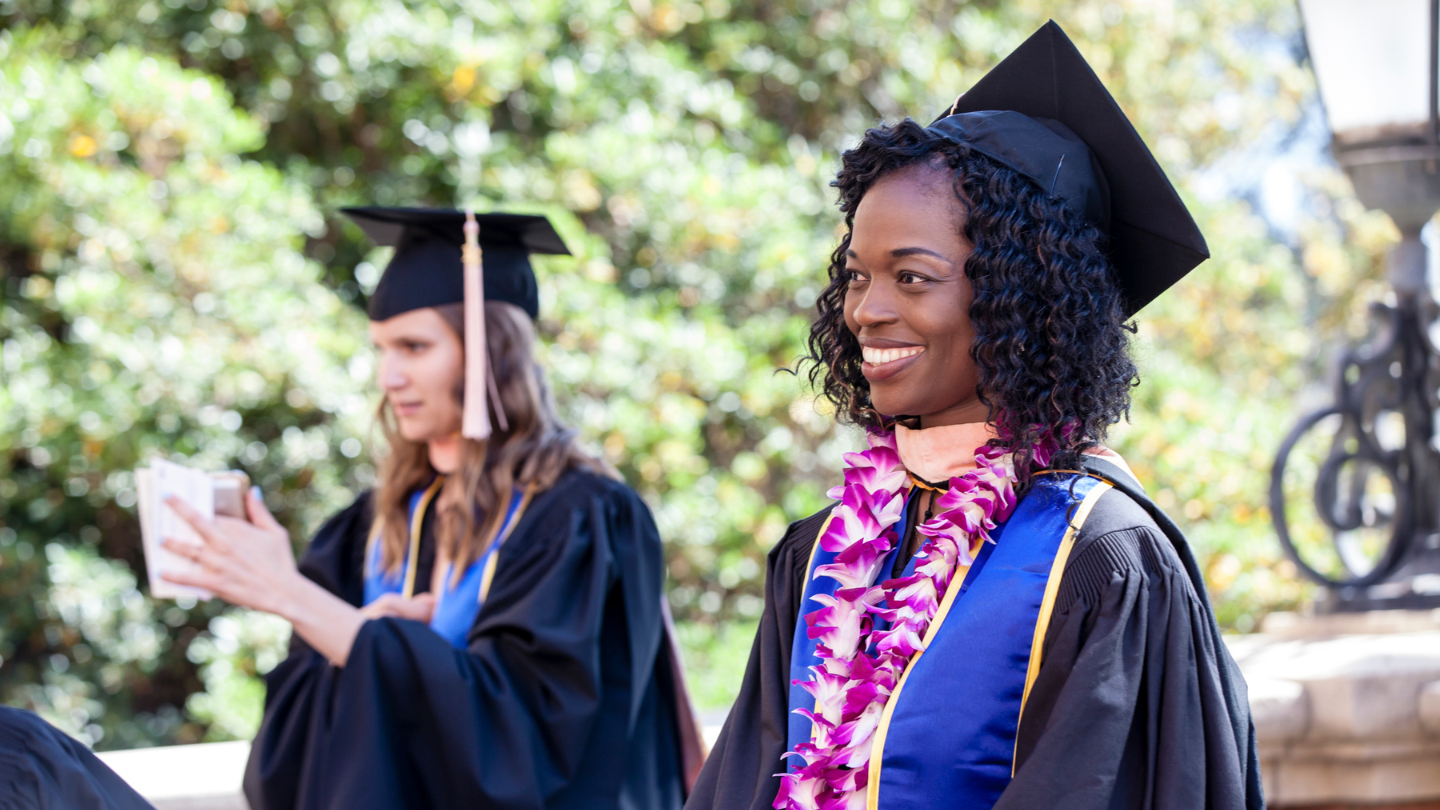 graduates smiling in cap and gown