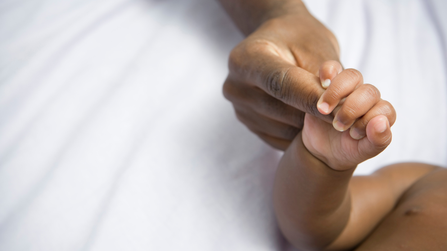 mother and baby holding hands