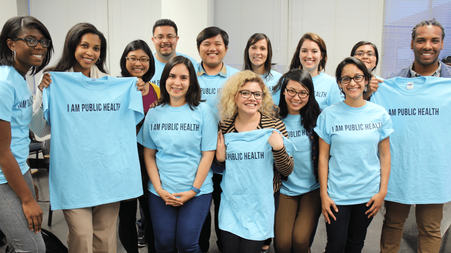 Public health students holding up "I am Public Health" T-shirts