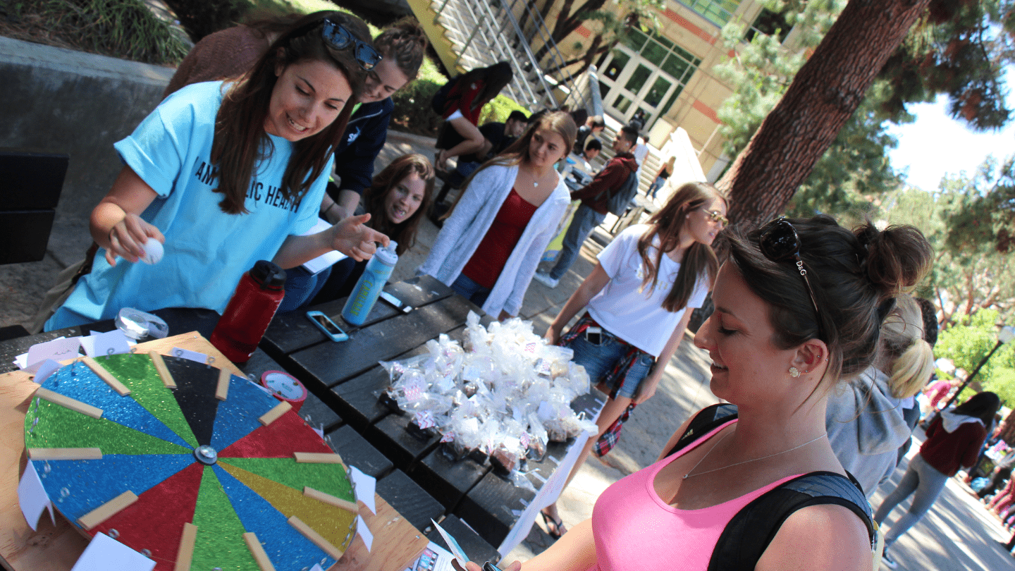 Female student spins the trivia wheel to be tested on sexual & reproductive health knowedge